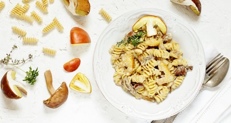 Fusilli paste with mushrooms Amanita Caesarea and boletus mushrooms and with cream. a family of fly-agarics of the highest category, a delicious mushroom. Italian Cuisine. copy space. top view  