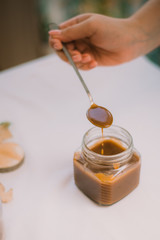 Homemade salty brown liquid caramel. Homemade soft caramel made from sugar on a background of apples and pumpkins