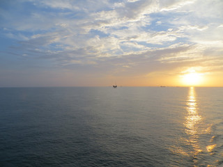 Obraz premium Ocean Sunset with Oil Rig