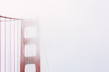 Tower and suspension cables of Golden Gate Bridge in the fog near San Francisco, California