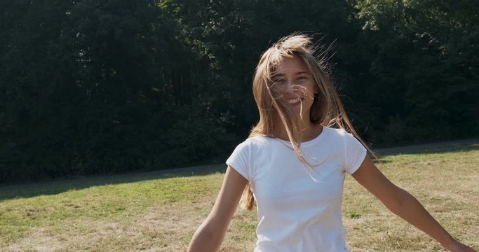 Follow me, young happy smilling girl running and asking you to follow her. Young atractive woman run and smile in the sun