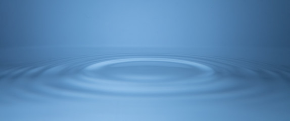 Ripples moving outward, concentric circles on calm, still water.