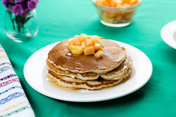 Oatmeal pancakes with tropical fruits on top.
