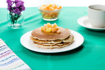 Oatmeal pancakes with tropical fruits on top.