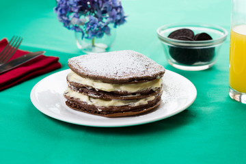A chocolate pancake with cream filling like Oreo.