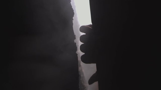 hands grabbing a wall in spooky light