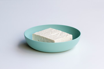 Fresh firm tofu in a bowl isolated on a white background.
