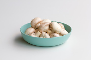 Fresh white mushrooms in a bowl isolated on a white background. 