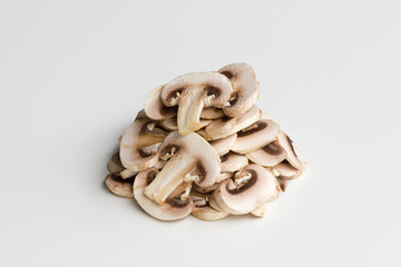 Fresh white mushroom slices stacked up and isolated on a white background.