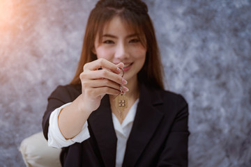 Close-up of Hands of a woman holding key from female real estate agent. rent house and sell ideas.