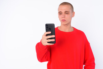 Portrait of young bald man using phone