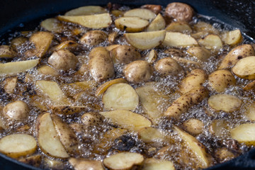 Roast potatoes in a large pan.Young potatoes are fried in oil, street food