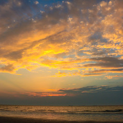 Beautiful golden sunset in the sea with saturated sky and clouds. Reflection in the water, epic sunset horizon at the ocean , nature background , uae nature 