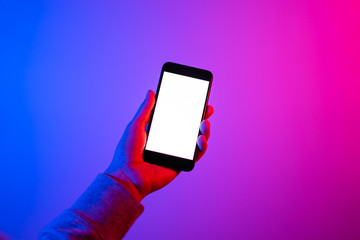 Male hands with smartphone. Empty white screen. Mock-up. Neon light