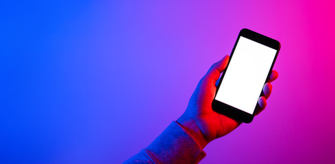 Male hands with smartphone. Blank white screen. Mock-up. Neon light