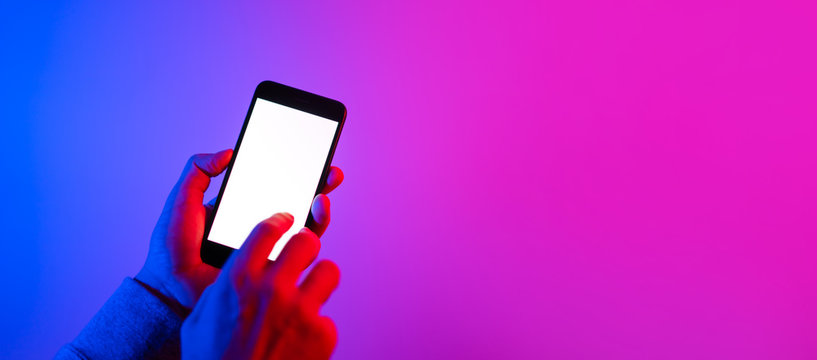 Male hands with smartphone. Blank white screen. Mock-up. Neon light