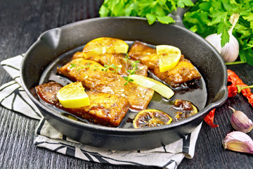 Salmon with sauce in pan on board