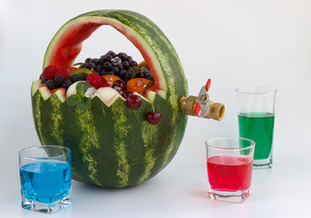 fruit basket and juice drain tap. the basket is made of watermelon and filled with different fruits