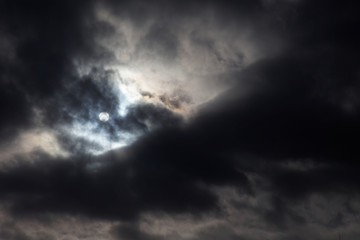 Obraz premium The sun is visible and hidden from between clouds