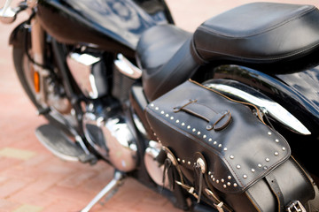 leather bag with metal rivets on the back of the motorcycle