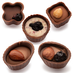 Five small chocolate basket with cream, nut and prunes on a white background