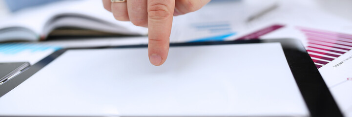 A male hand in a business suit makes a clean display of the tablet with his finger