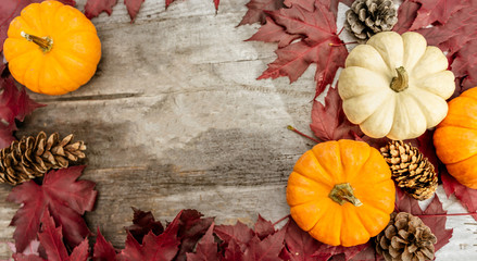 Festive autumn decor from pumpkins, pine and leaves on a  wooden background. Concept of Thanksgiving day or Halloween. Flat lay autumn composition with copy space.