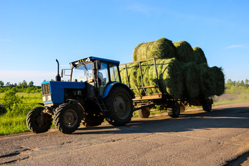 tractor driven fresh hay rolled, after seasonal harvesting © Оксана Скиданова