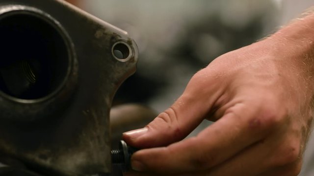 Close up of 2 caucasian men pulling apart an engine block