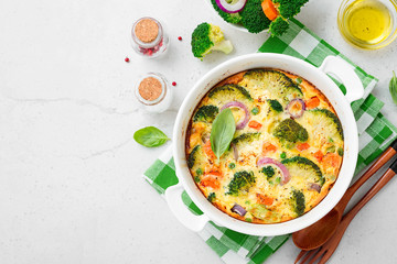 Frittata or casserole with broccoli and vegetables in baking dish. Vegetarian recipe.