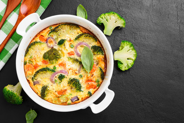 Frittata or casserole with broccoli and vegetables in baking dish. Vegetarian recipe.