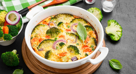 Frittata or casserole with broccoli and vegetables in baking dish. Vegetarian recipe.