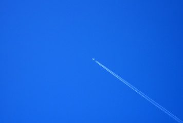 Airplane Flying In Blue Sky With White Smoke.