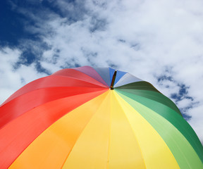 Rainbow umbrella on blue sky background
