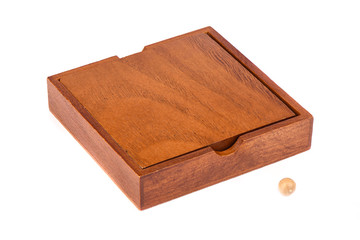 Wooden box and ball for playing Madagascar checkers over a white background.