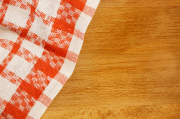 Fototapeta na wymiar Red tablecloth on wooden taRed tablecloth on wooden table backgroundble background