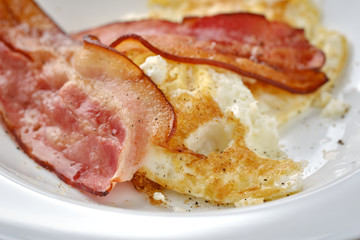 fried bacon and eggs on breakfast close up