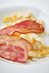 fried bacon and eggs on breakfast close up