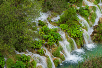 Rushing pure fresh water cascades down the natural barriers into the turquoise colored Lake Kaluđerovac at the Plitvice Lakes National Park in Croatia