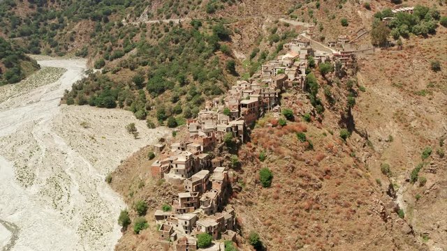 Roghudi Vecchio fascinating Italian ghost town located in Aspromonte mountains in Southern Italy. It was abandoned in 1973 after a series of natural disasters (flood). Travel destination. Aerial Shot.