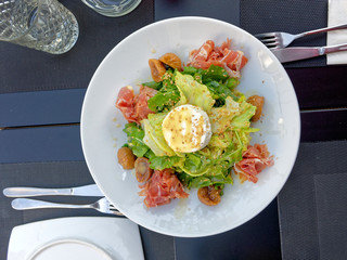 gourmet green salad plate served with proschiutto and ricotta white cheese, top view