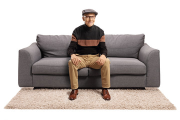 Elderly man sitting on a sofa and smiling