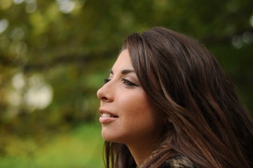Fototapeta premium Portrait of a girl with long curly hair in a park