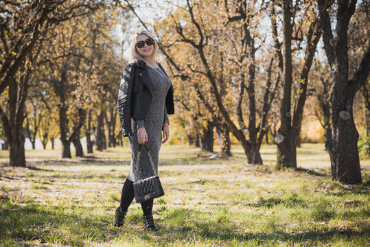 Happy woman of plus size, American or European appearance enjoying life. Young lady with excess weight, stylishly dressed at nature .Natural beauty - Powered by Adobe