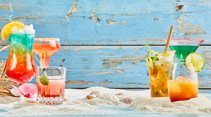 Different colorful tropical cocktails on a beach