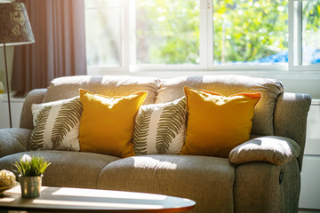 Vintage sofa and pillows in living room with sunlight in the morning. Relax corner concept. - Powered by Adobe