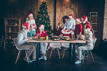 Merry x-mas family meeting on christmas eve joyful man in santa claus hat cap hold sack bag give giftboxes wish follow tradition meal amaze small little kid sister mature people sit table house