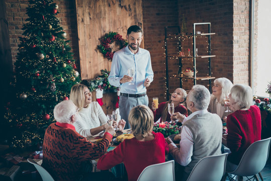 Photo of full big family gathering sit dinner table father guy telling x-mas toast multi-generation eight members harmony in newyear decorated living room indoors