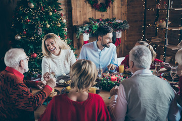 Photo of full family gathering sitting dinner table communicating chatting overjoyed x-mas party multi-generation in newyear decorated living room indoors