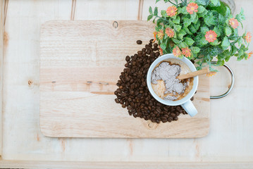 The decoration of coffee beans and a cup of coffee with a delicate aroma and flowers.
